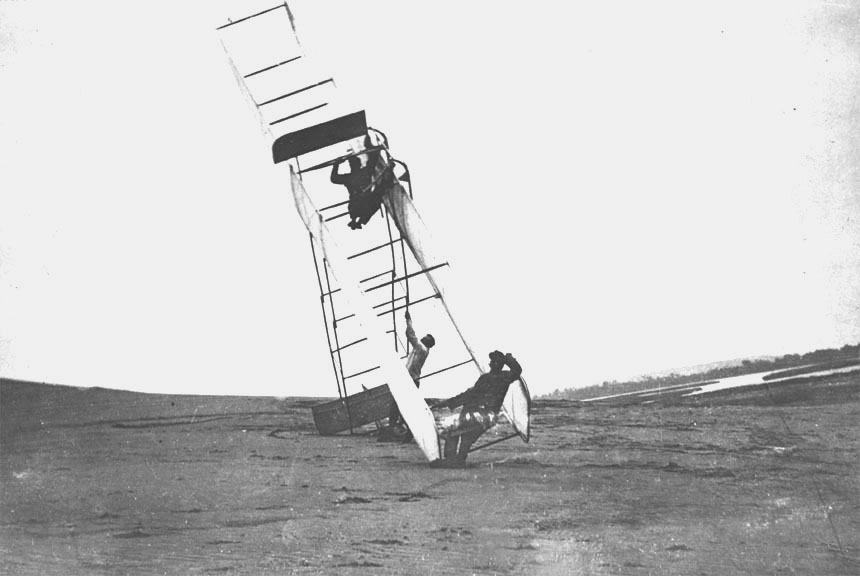 Machine_turning_over_with_Orville_Wright_aboard_Kitty_Hawk_NC_1911.10470_A.S.